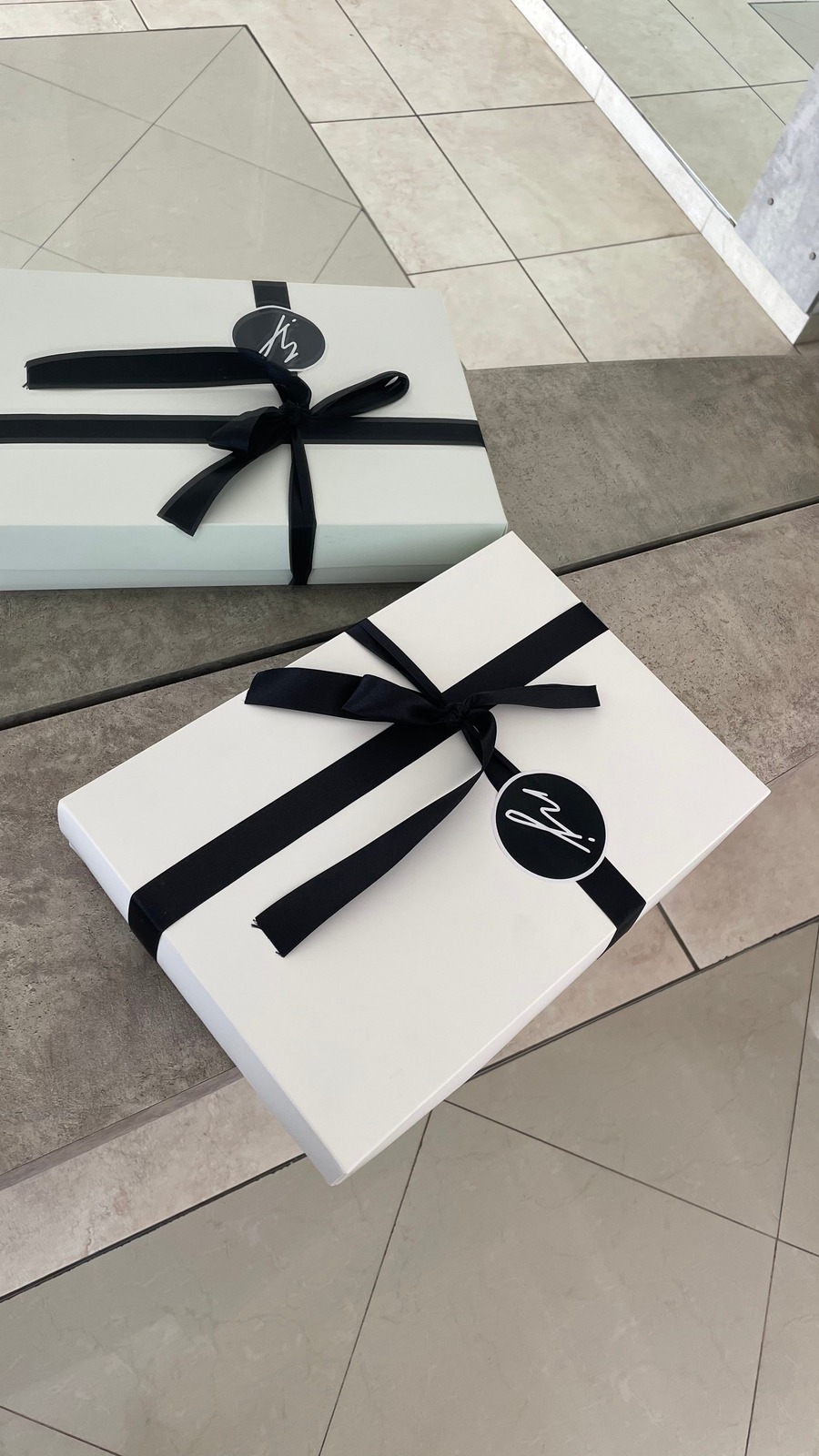 Presentación de regalo NJ Ink con cajas blancas y cintas negras